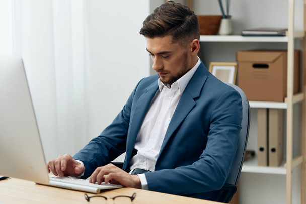 Ein Mann im Anzug mit Brille arbeitet in einem Computerbüro. Hochwertiges Foto - Foto, Bild