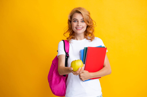 Innoissaan punapää nuori nainen opiskelija reppu pidä muistikirjat, eristetty keltainen tausta studio Koulutus lukion yliopisto College - Valokuva, kuva
