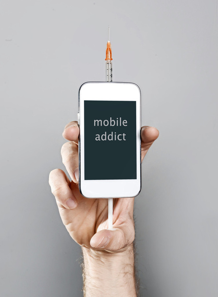 telefon Internet addict trzymając telefon komórkowy z strzykawki w uzależnienia koncepcja człowieka - Zdjęcie, obraz