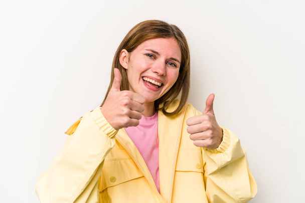 Молода англійська жінка ізольована на білому фоні піднімаючи як великі пальці вгору, посміхаючись і впевнено. - Фото, зображення