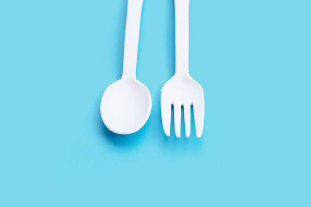 Fourchette et cuillère en plastique sur fond bleu. - Photo, image