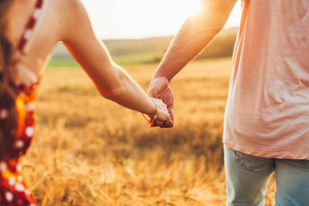 Zavřít venkovní portrét páru držícího se za ruce v pšeničném poli. Symbol lásky a šťastného vztahu. Milující pár držící se za ruce. Romantika. Léto - Fotografie, Obrázek