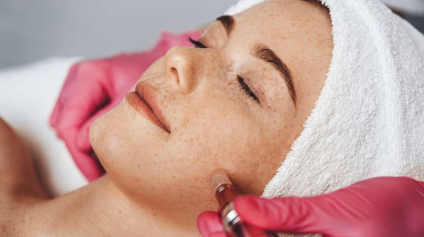 Egy nő elektrostimulációs emelő terápiát kap a spa szalonban. Szépség bőr. Kozmetikai szépségszalon. Arckezelés. - Fotó, kép