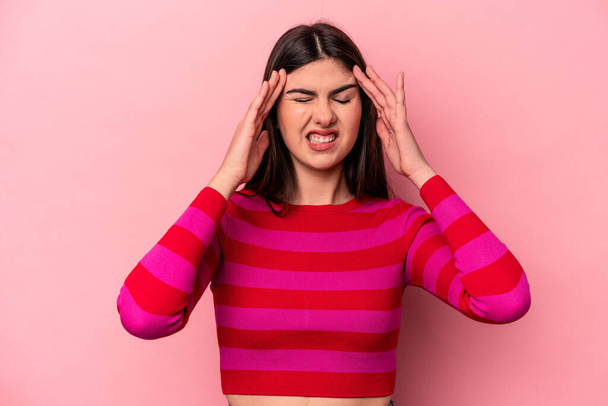 Junge kaukasische Frau isoliert auf rosa Hintergrund berührt Schläfen und hat Kopfschmerzen. - Foto, Bild