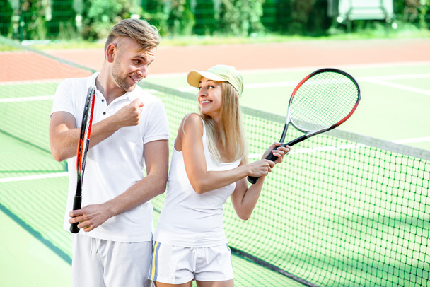若いカップルがテニスをしていて - 写真・画像