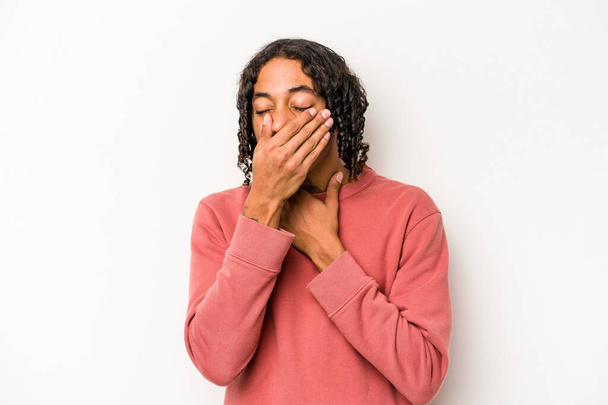Hombre afroamericano joven aislado sobre fondo blanco sufre dolor de garganta debido a un virus o infección. - Foto, imagen