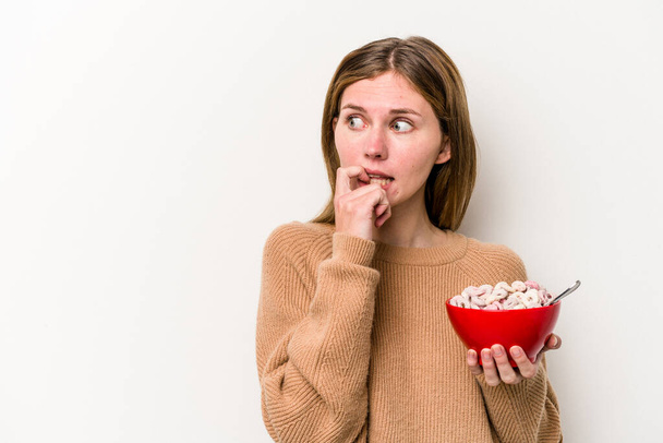Giovane donna inglese mangiare cereali isolati su sfondo bianco rilassato pensando a qualcosa guardando uno spazio copia. - Foto, immagini