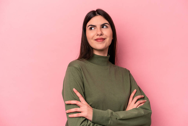 Junge kaukasische Frau isoliert auf rosa Hintergrund träumt davon, Ziele und Ziele zu erreichen - Foto, Bild