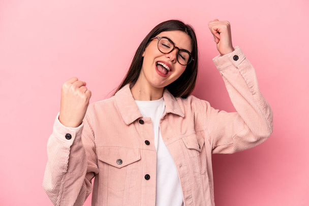 Young caucasian woman isolated on pink background cheering carefree and excited. Victory concept. - Fotoğraf, Görsel