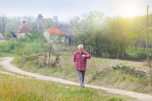 Пенсионер прогуливается по деревне
 - Фото, изображение