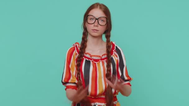 Dont want to hear and listen. Frustrated annoyed irritated redhead girl covering ears and gesturing no, avoiding advice ignoring unpleasant noise loud voices. Young ginger child kid on blue background - Footage, Video