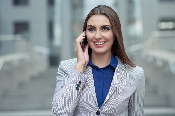 mujer de negocios hablando en un teléfono celular en el fondo de la
  - Foto, Imagen