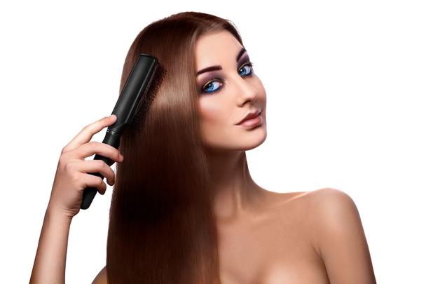 Girl combing perfect long hair and looking at camera with blue e - Photo, image