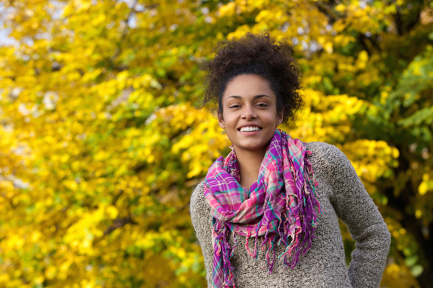 Beautiful young black woman smiling outdoors in autumn - Photo, Image