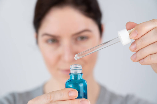 Caucasian woman uses blue anti-wrinkle face serum - Foto, immagini