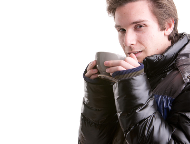 young man having a hot drink in winter - Photo, Image