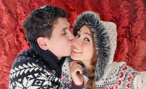クリスマスの時期に楽しんで幸せなキス カップル - 写真・画像