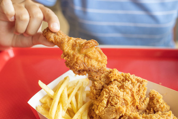 gros plan les gens qui mangent du poulet frit avec bâton de pomme de terre frites nourriture grasse à l'américaine. - Photo, image