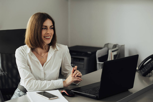 Portrait d'une jeune femme joyeuse travaillant au bureau, comptable féminine au travail - Photo, image
