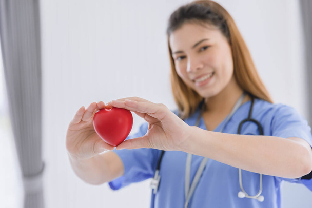 красива медсестра лікарка жінка щаслива посмішка з любов'ю серце для охорони здоров'я гостинності та концепції сервісного обслуговування
. - Фото, зображення