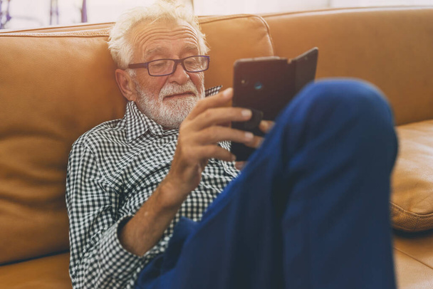 vanhempi iäkäs mies rentoutua istuu nauttia matkapuhelimen elämäntapa älypuhelimen addikti kypsiä ihmisiä käsite. - Valokuva, kuva