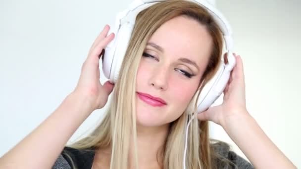 Woman listening to music with white headphones - Felvétel, videó