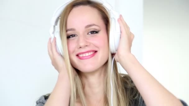 Woman listening to music with white headphones - Filmmaterial, Video