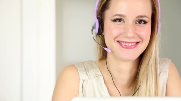 Woman with headphones on computer talking to customer - Footage, Video