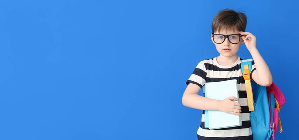 Cute little schoolboy on blue background with space for text - Foto, Imagem