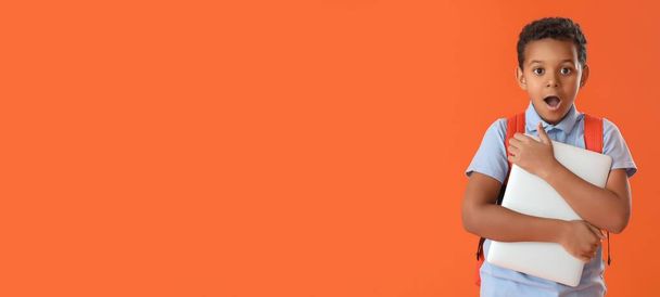 Cute surprised African-American schoolboy on orange background with space for text - Photo, Image