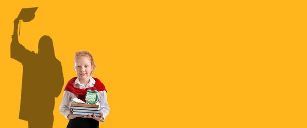Cute schoolgirl dreaming about higher education on yellow background with space for text - Photo, Image