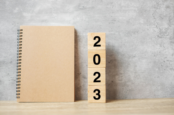 2023 Frohes Neues Jahr mit leerem Notizbuch und Holzzahl. Countdown, Resolution, Ziele, Plan, Aktion und Missionskonzept - Foto, Bild