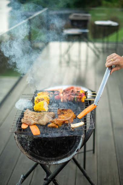 finom grillezett hús füsttel, Grill zöldséggel a szabadban. Grill, party, életmód és piknik koncepció - Fotó, kép