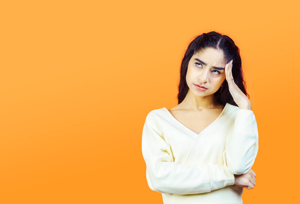 Tired and fed up concept with beautiful brunette woman on orange background with copy space. - Zdjęcie, obraz