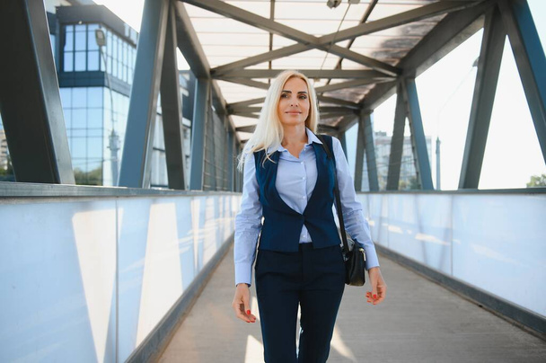 Close up portrait of a serious business woman in blue suit standing in the city. - Fotó, kép