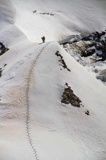 Skier climbing a snowy mountain - Фото, зображення