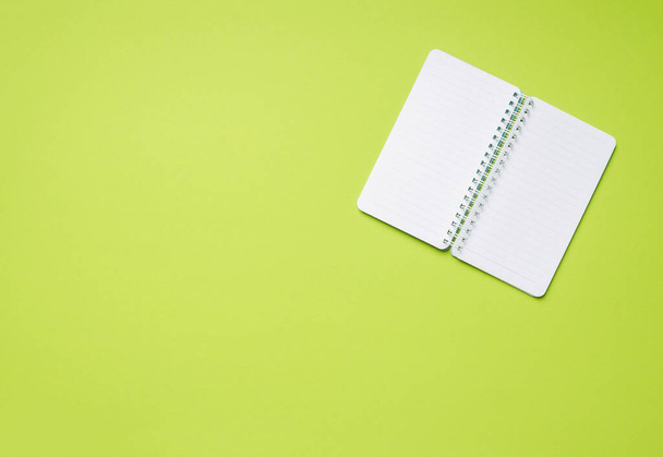 Mockup empty spring notebook with copy space on a green background. Top view. - Fotó, kép