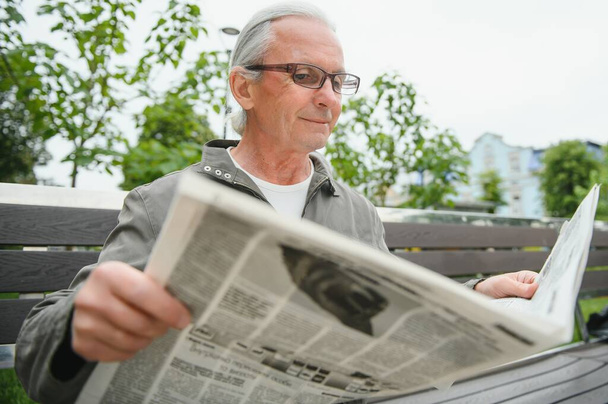 Old gray-haired man rest on the bench in summer park. - Φωτογραφία, εικόνα