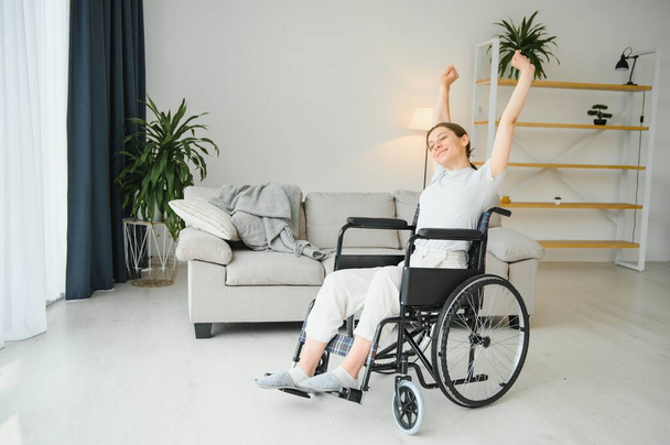 Woman in wheelchair working out in living room. - Foto, Imagem