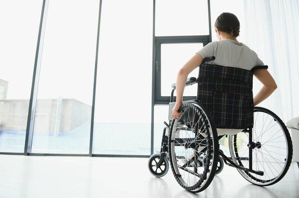 Young woman in wheelchair at home in living room - Foto, Imagen