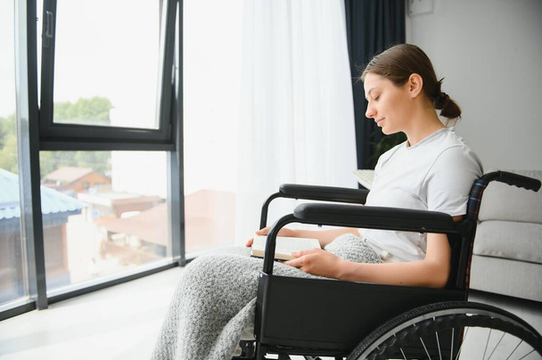 Молодая женщина в инвалидной коляске дома
. - Фото, изображение