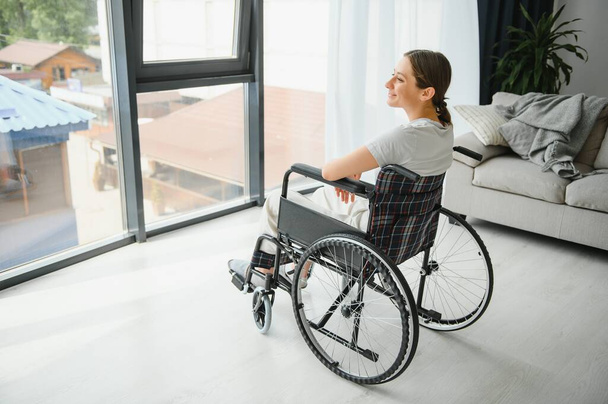 Young woman in wheelchair at home. - Fotografie, Obrázek