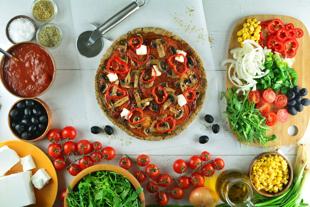 pizza fresca sobre fondo negro con ingredientes - Foto, Imagen