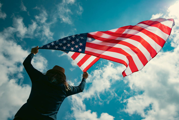 Young woman holding american USA flag. Independence Day or traveling in America concept.  - 写真・画像