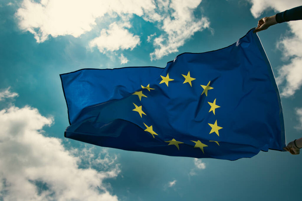 Waving European Union flag on blue sky. - 写真・画像