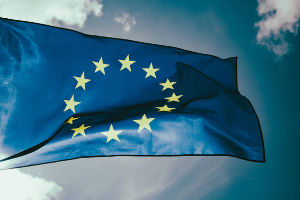 Waving European Union flag on blue sky. - Фото, зображення