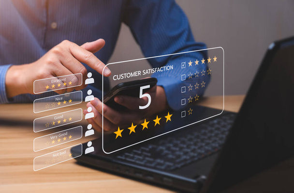 Customer satisfaction concept. Hands of a business man using a smartphone to comment 5 stars. Excellent business rating experience. Satisfaction Rating, good and impressive - Photo, Image