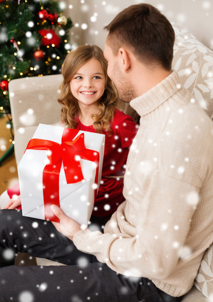 smiling father and daughter with gift box at home - Фото, зображення