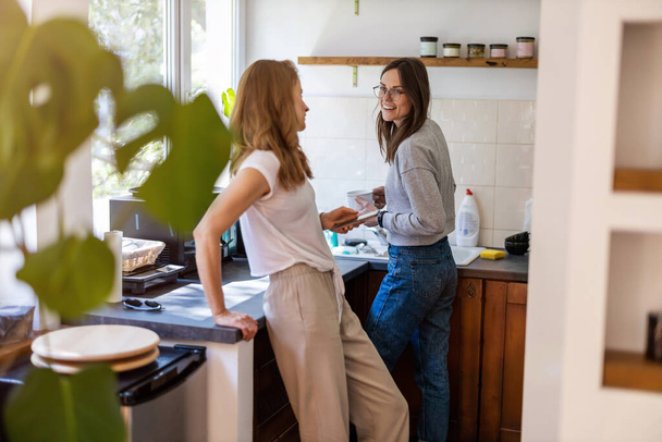 Δύο γυναίκες που περνούν χρόνο στην κουζίνα στο σπίτι - Φωτογραφία, εικόνα
