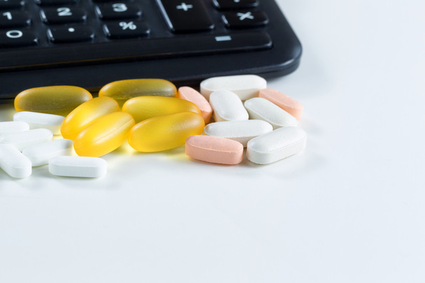 Erilaisia lääkkeitä edessä laskin valkoinen
  - Valokuva, kuva